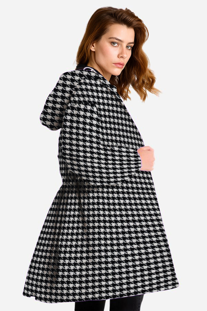 A woman with shoulder-length brown hair models the looselyboho HOUNDSTOOTH WINDBREAKER, featuring a stylish black and white check pattern. She faces slightly to the side with a neutral expression against a plain background.