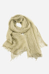 A light beige, loosely woven scarf with frayed edges, made from ultra-breathable linen, is displayed against a white background. The Lightweight Linen Scarf from looselyboho appears soft and lightweight, exuding artisanal charm and suitable for casual wear.