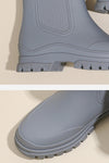 Close-up image of grey Non-Slip Rain Boots. The lower half of the boot features a textured sole with SuperGrip Soles, providing exceptional traction. The upper part of the boot displays a sleek, smooth design. Waterproof and designed for comfort support, the image showcases the side profile and front top view of the boot by looselyboho.