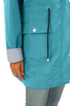 A person wearing a looselyboho STRIPED TURQUOISE OASIS WINDBREAKER JACKET with snap-button pockets and a drawstring stands with their arm slightly extended. The person has a blue and white striped shirt cuff showing and is wearing light-wash jeans.